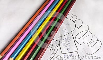 Seven colorful bright pencils lie on childish scribbles Stock Photo