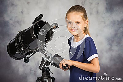 Seven-year girl adjusts the telescope and looked into the frame Stock Photo