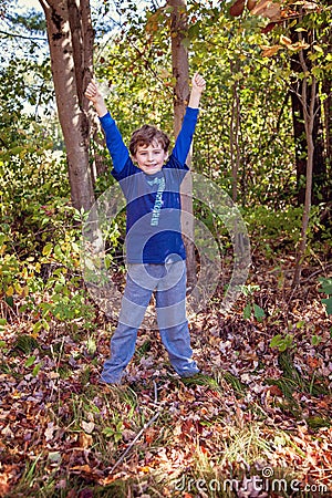 Seven year old birthday boy wearing 7 shirt with hands up Stock Photo