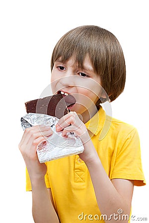 A seven years boy is biting a stick of chocolate Stock Photo