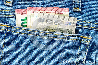 Several bills of five and ten euros in the back pocket of jeans. Concept of absentminded person, potential victim of theft Stock Photo