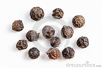 Several black pepper peppercorns close up on gray Stock Photo