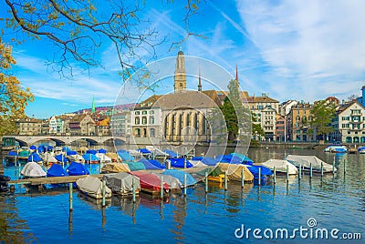 several boats are anchoring on the limmat river in zurich with famous Grossmunster cathedral behind them...IMAGE Editorial Stock Photo