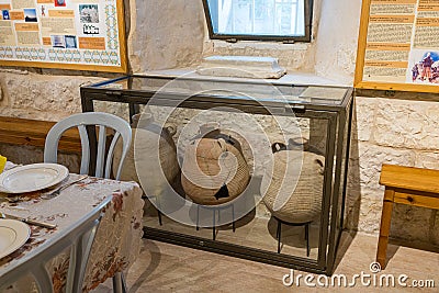 Several broken and restored jugs in a glass case stand in the guest room on the territory on site of Emmaus Nicopolis Editorial Stock Photo