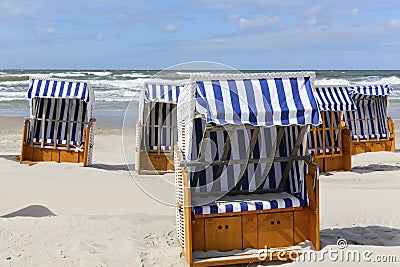 Several canopied beach chairs by a sea coast Stock Photo