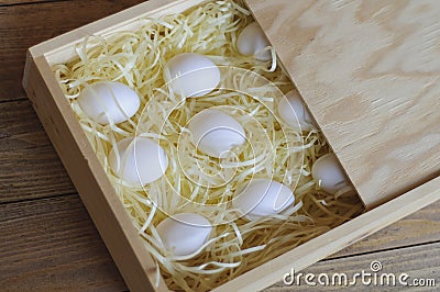 Several chicken white eggs in a wooden box. Stock Photo