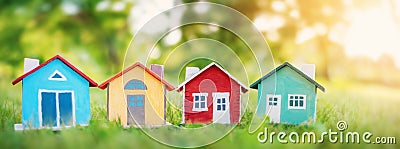 Several colourful houses models standing on the green grass. Stock Photo