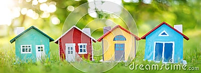 Several colourful houses models standing on the green grass. Stock Photo