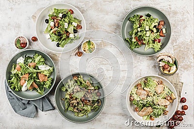 Several dishes with salads from fresh vegetables with fish and meat in different bowls Stock Photo