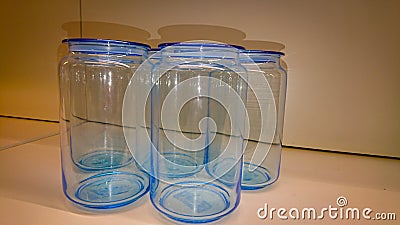 Several empty blue glass jars stand on a shelf Stock Photo