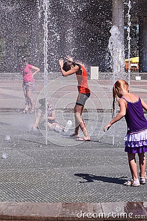 Several girls play in the city fountain Editorial Stock Photo