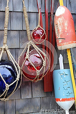 Several glass ornaments and buoys on seaside homes with clapboard siding, Rockport, Mass, 2019 Stock Photo