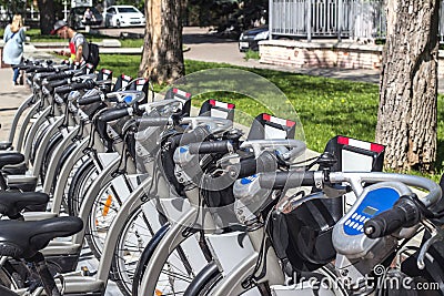 Several grey city bikes in automatic rental Editorial Stock Photo