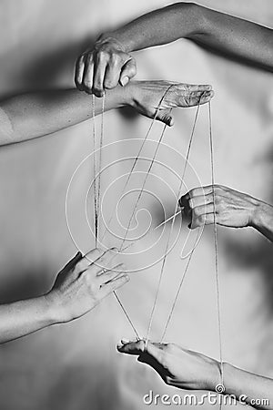 Several hands joined with a thin rope making various connections between people. Stock Photo