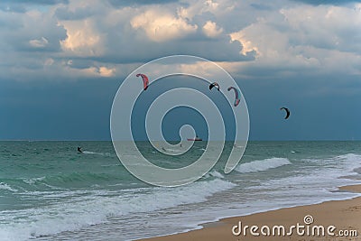 Several kite-surfers fighting with gusty windy weather and waves in the ocean. Amazing adventure and adrenaline sport Stock Photo