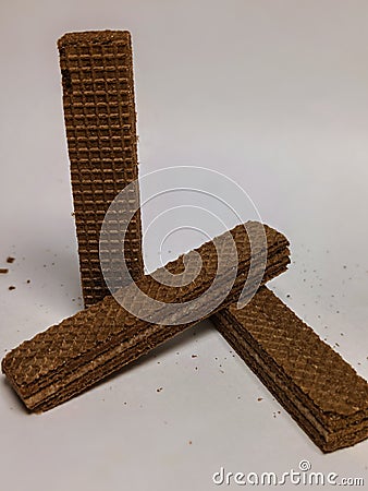 several layered chocolate wafer cakes, filled with white cream, textured with rectangular boxes on a white background Stock Photo