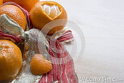 Several mandarins and peel in form of heart are on the ribbon Stock Photo