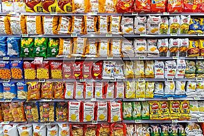 Several packs of chips and snack. Shelves with different brands of potato chips. Editorial Stock Photo