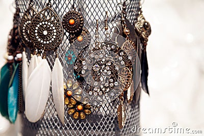 Several pairs of bronze colored vintage earrings on a jewelry stand at the market Stock Photo