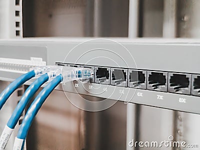 Several RJ45 Ethernet cables plugged into a switch inside a server rack of a company to link computer together into a network. Stock Photo