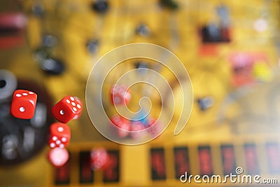 Several rolling red dice fall on a table with boardgame. Gameplay moments Stock Photo