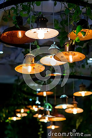 Several round loft style suspended luminaires with edison lamps shine a warm light. Stock Photo