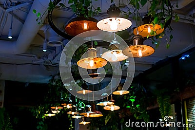 Several round loft style suspended luminaires with edison lamps shine a warm light. Stock Photo