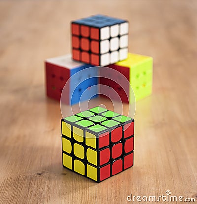 Madrid, Spain; 9 february 2019: Several Rubik cubes intelligence toys solved, in a wood table Editorial Stock Photo