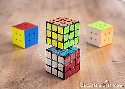 Madrid, Spain; 9 february 2019: Several Rubik cubes intelligence toys solved, in a wood table Editorial Stock Photo