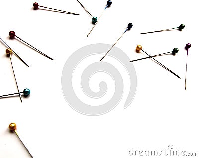 Several sewing pins with colored beads lie on a white isolated background. Place for text. View from above. Stock Photo