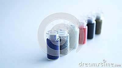 Several small cans with colored beads for manicure. Stock Photo