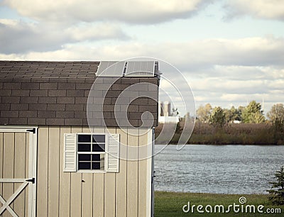 Several solar panels on the roof of small outbuilding. Stock Photo