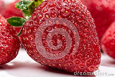 Several strawberries with drops of pure water very close up on a white background Stock Photo