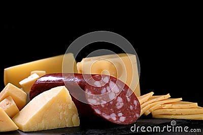 cheese and piece of salami loaf are on black background Stock Photo