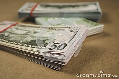 several wads of cash lying on top of each other on a beige background Stock Photo