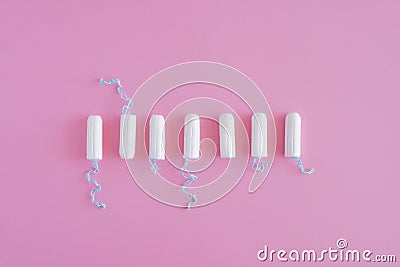 Several white sanitary tampons on a pink background. Stock Photo