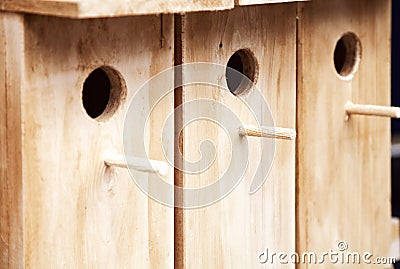 Several wooden birdhouses in a row background. A few wood bird houses for sale Stock Photo