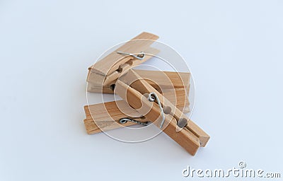 Several wooden clothes pins lying on each other on a white background. Close up Stock Photo