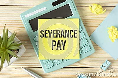 Severance Pay on the table, calculator and paper clips on wooden background Stock Photo