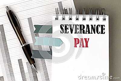 SEVERANCE PAY text on notebook with pen, calculator and chart on a grey background Stock Photo