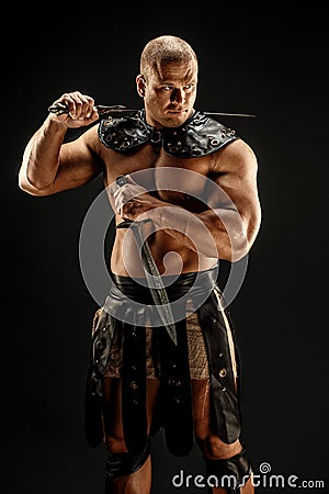 Severe barbarian in leather costume with sword Stock Photo