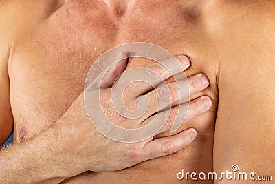 Man suffering from chest pain, having heart attack or painful cramps, pressing on chest with painful expression on blue backgound. Stock Photo