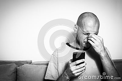 Severe migraine attack on the man after prolonged use of the mobile phone, black and white Stock Photo