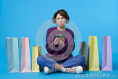 Severe young attractive short haired brunette lady with short haircut biting her lips while looking pensively upwards, wearing Stock Photo