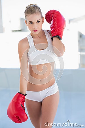 Severe young blonde model wearing boxing gloves Stock Photo