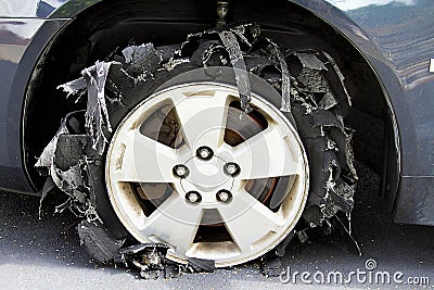 Severely Blown-out Tire with rubber ripped to shreds. Stock Photo