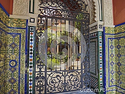 typical spanish patio with wrought iron gate, tiles and flowers Editorial Stock Photo