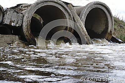 The sewage water flows through the old pipe Stock Photo