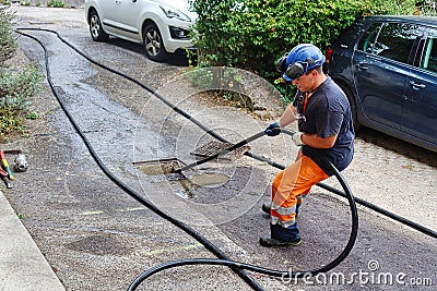 sewer cleaning and worker with water and hose in pipe Editorial Stock Photo