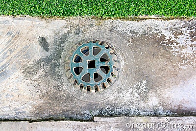 Sewer grate on concrete drain floor. Clogged street drain. Sewer cover. Metal sewer cover Stock Photo